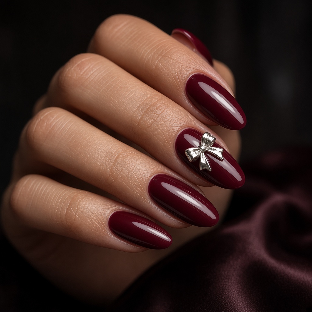 Kuku almond burgundy glossy dengan aksen kristal